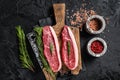 Raw cap rump beef meat steak or top sirloin on butcher board. Black background. Top view Royalty Free Stock Photo