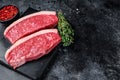 Raw cap rump steak or top sirloin beef meat steak on marble board. Black background. Top view. Copy space Royalty Free Stock Photo