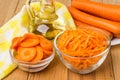 Raw carrot in transparent bowls, bottle vegetable oil and napkin