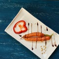 Raw carrots and bell pepper slice on flat rectangular plate