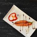 Raw carrots and bell pepper slice on flat rectangular plate