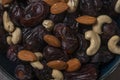 Raw cashew nuts and figs served in black bowl .