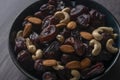 Raw cashew nuts and figs served in black bowl .