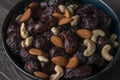 Raw cashew nuts and figs served in black bowl .