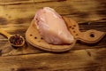 Raw chicken breast on cutting board on wooden table Royalty Free Stock Photo
