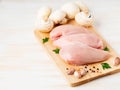 Raw chicken breast fillet with spices on wooden board on white wooden table, side view, copy space Royalty Free Stock Photo