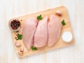 Raw chicken breast fillet with spices on wooden board on white wooden table, top view Royalty Free Stock Photo