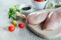 Raw chicken breast fillets and ingredients for dinner on wooden board on concrete table background Royalty Free Stock Photo