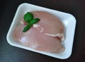 Raw chicken breast fillets skinned with basil leaves