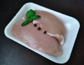 Raw chicken breast fillets skinned with basil leaves and pepper