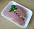 Raw chicken breast fillets skinned with basil leaves and pepper