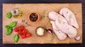 Raw chicken breast fillets on wooden cutting board with herbs and spices. Royalty Free Stock Photo