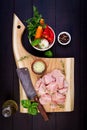 Raw chicken breast fillets on wooden cutting board with herbs and spices. Royalty Free Stock Photo