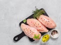 Raw chicken breast with fresh basil and thyme on black cuttingboard, copyspace