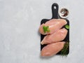 Raw chicken breast with fresh basil and thyme on black cuttingboard Royalty Free Stock Photo