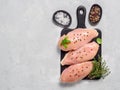 Raw chicken breast with fresh basil and thyme on black cuttingboard, copyspace Royalty Free Stock Photo