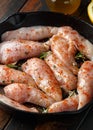 Raw chicken breast mini fillets in rastic cast iron skillet, frying pan with herbs and sea salt Royalty Free Stock Photo