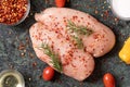 Raw chicken breast with rosemary, vegetables and red pepper on green marble cutting board