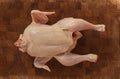 Raw chicken on a chopping board ready to be prepared for cooking. Top view image on wooden background