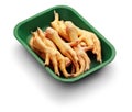 Raw chicken claw in a green tray over white background Royalty Free Stock Photo