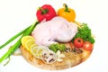 Raw chicken on a cutting board with garnished vegetables with a white background Royalty Free Stock Photo