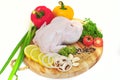 Raw chicken on a cutting board with garnished vegetables with a white background Royalty Free Stock Photo