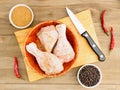 Raw chicken drumsticks in a bamboo bowl, knife, masala, black pepper, red chili Royalty Free Stock Photo