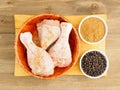 Raw chicken drumsticks in a bamboo bowl, masala, black pepper Royalty Free Stock Photo
