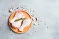 Raw chicken drumsticks with seasonings and spices on wooden plate over gray concrete table background Royalty Free Stock Photo