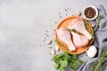 Raw chicken drumsticks with seasonings on wooden plate over gray concrete table. Chicken legs ready to cook Royalty Free Stock Photo