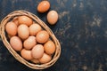 Raw chicken eggs in a basket on a rustic background. Top view, copy space. Royalty Free Stock Photo