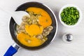 Raw chicken eggs with fried mushrooms, salt, bowl with scallion