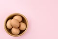 Raw chicken eggs on pink background, top view. Space for text