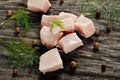 Raw chicken fillet cut into cubes with spices on a wooden surface