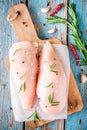 Raw chicken fillet with garlic, pepper and rosemary on rustic background