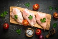 Raw chicken fillet meat on cutting board.