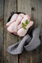 Raw chicken legs on a cast iron pot with spices and herbs on old wooden background prepared for cooking. Selective focus. Top view Royalty Free Stock Photo