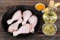 Raw chicken legs in iron frying pan, oil and spices Royalty Free Stock Photo