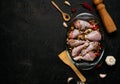 Raw chicken legs and lots of spice in a transparent dish on a black background. Royalty Free Stock Photo