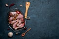 Raw chicken legs and lots of spice in a transparent dish on a dark background. Royalty Free Stock Photo