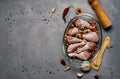 Raw chicken legs and lots of spice in a transparent dish on a grey background. Royalty Free Stock Photo