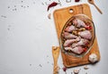 Raw chicken legs and lots of spice in a transparent dish on a white background. Royalty Free Stock Photo