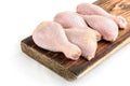 Raw chicken legs on wooden cutting board isolated on white background Royalty Free Stock Photo