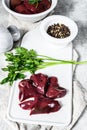 Raw chicken liver in a bowl. Gray background. Top view