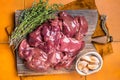 Raw chicken liver, fresh fowl giblets on wooden board. Orange background. Top view