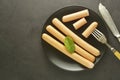 Raw chicken meat hot dog sausages breakfast. Dark background. Sausages in black plate