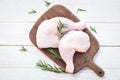 Raw chicken meat with rosemary / fresh raw chicken leg fillet on wooden cutting board background Royalty Free Stock Photo