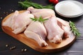 Raw chicken meat and chicken wings being placed on the cutting board