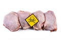 Raw chicken meat with yellow poisonous skull warning sign, concept for meat contaminated with bacterium, germs, antibiotics