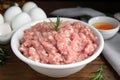 Raw chicken minced meat with rosemary on wooden table, closeup